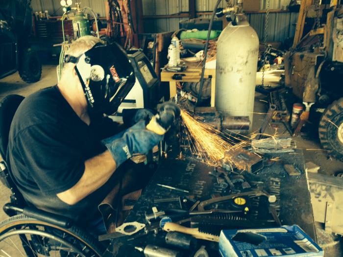 Me sitting at my welding bench made from unfinished wood stove